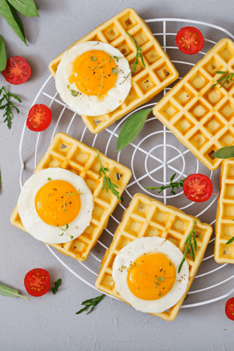 gluten-free waffles topped with fried eggs over a rack