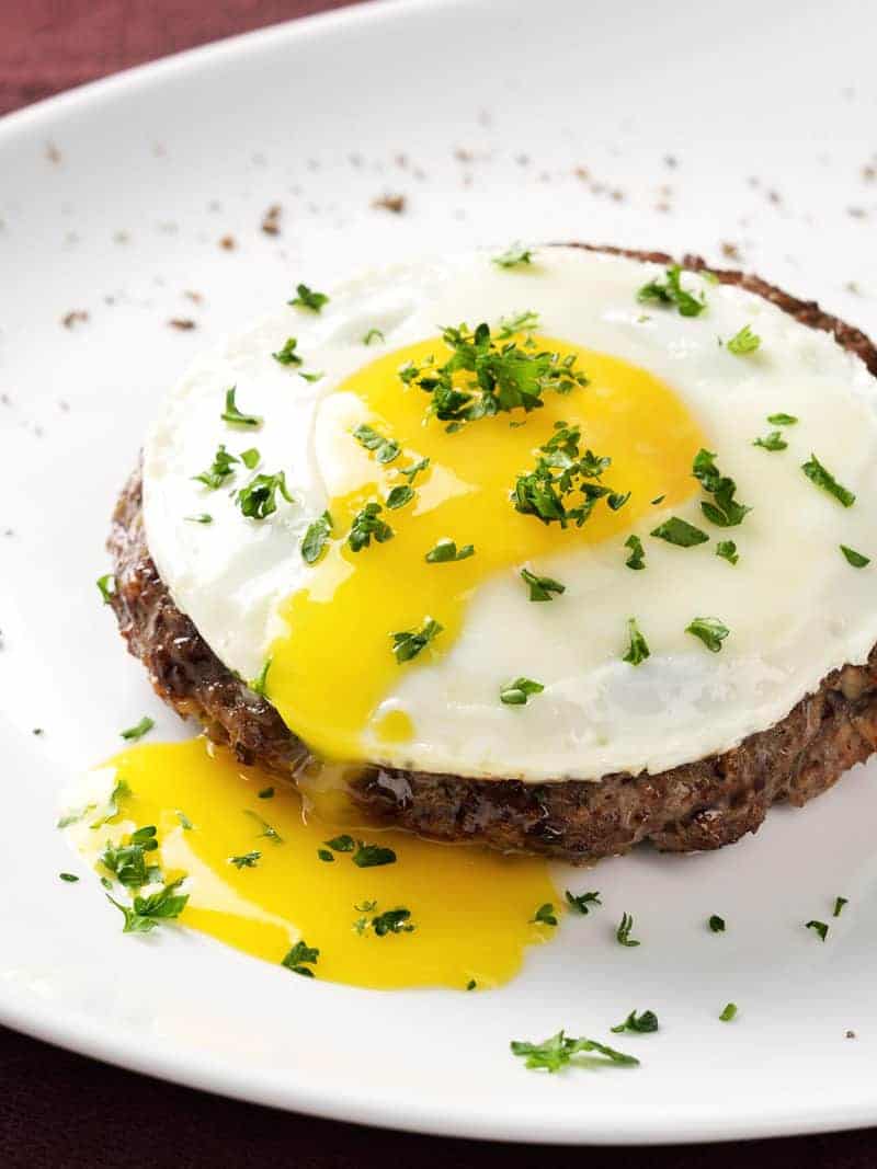 sunny side up egg with runny egg yolk with chopped herbs on top