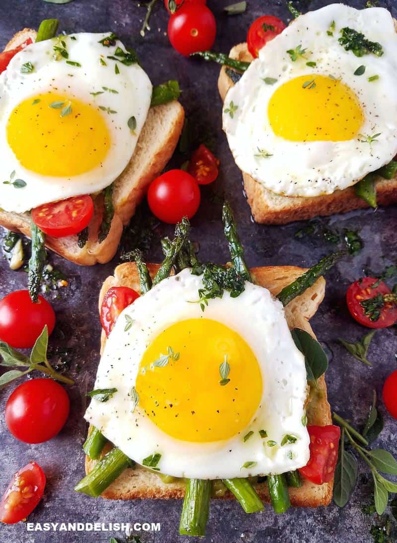 3 sunny side up eggs on toast each with veggies