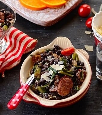 A bowl of salad with sausage and beans