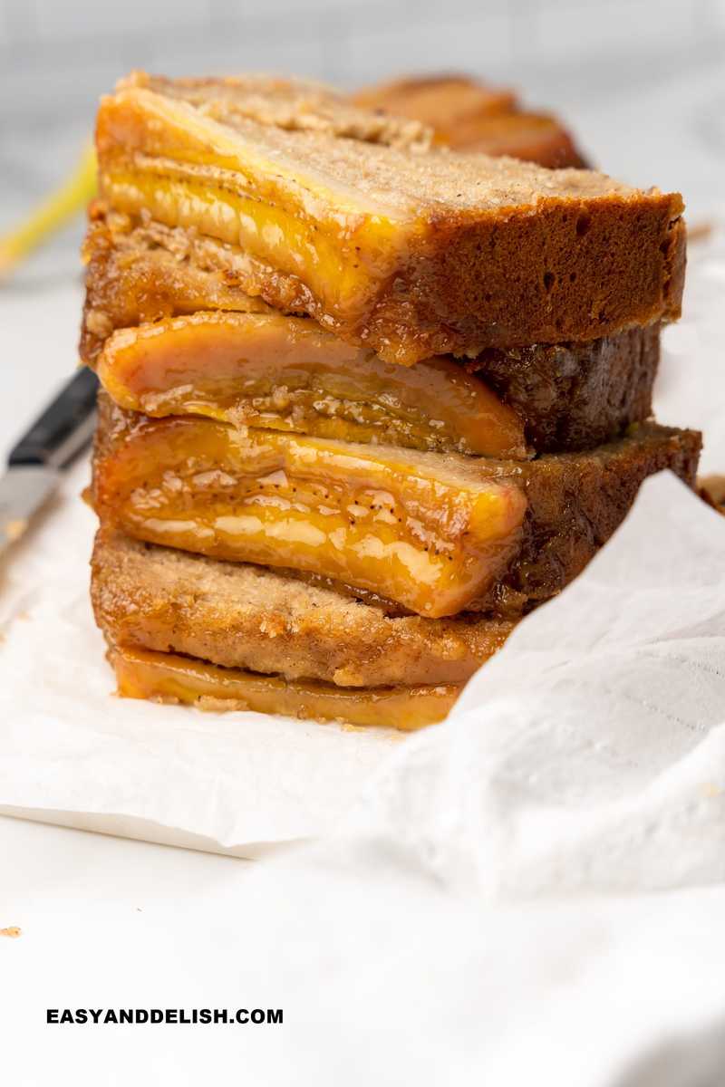 a stack of sliced moist banana bread over a cutting board