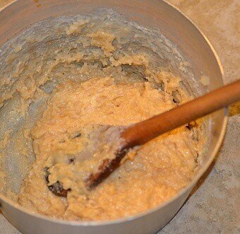 Ingredients for cocada de leite condensado or Brazilian coconut bars being mixed with a wooden spoon in a bowl