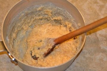 Ingredients for cocada de leite condensado or Brazilian coconut bars being mixed with a wooden spoon in a bowl