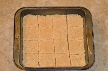 Brazilian coconut bars or cocada de leite condensado cut into squares in a pan