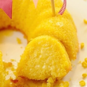A slice of corn cake close to the rest of the cake decorated with a flag bunting on top
