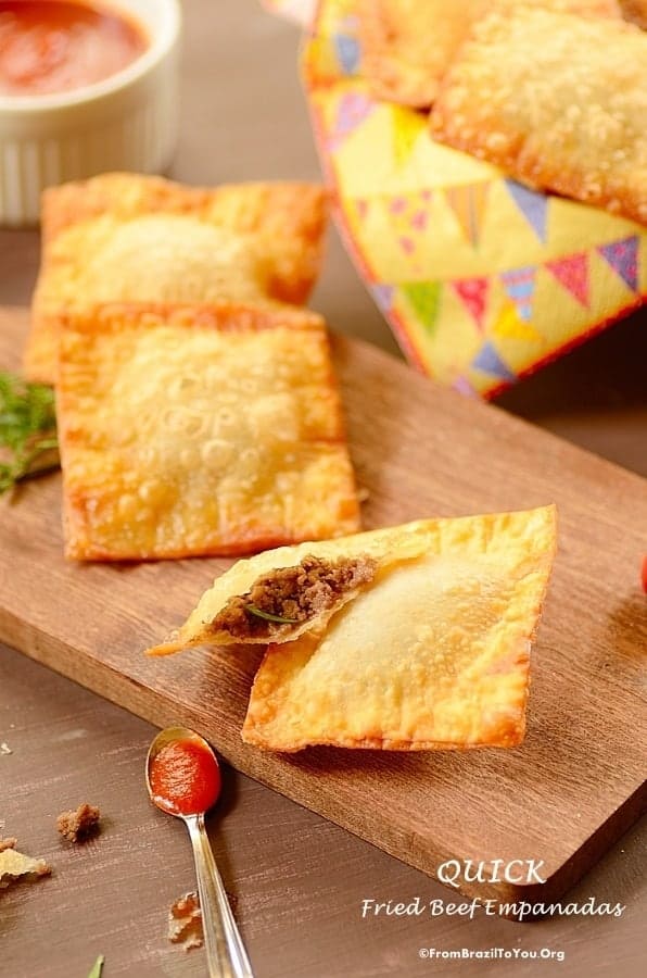 pastel de carne deep fried empanadas on a wooden serving board