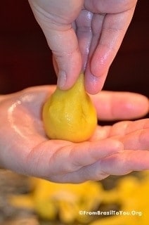 The coxinha dough is shaped into a little drumstick by pinching and prodding with the fingers