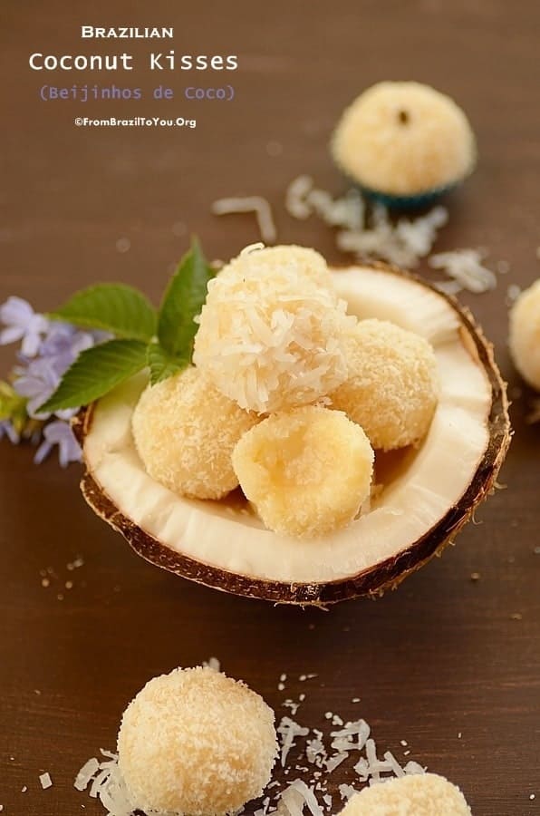 Brazilian Coconut Kisses (Beijinhos de Coco) in a coconut shell and also over the table