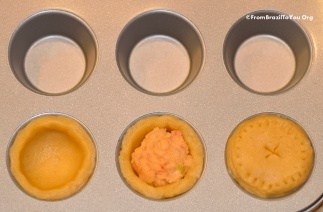 Discs of dough for shrimp mini pot pies are placed in the wells of a muffin tin and filled with shrimp filling