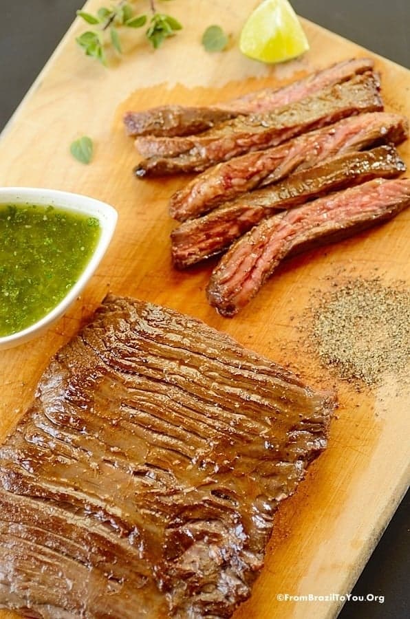 How to Cook Skirt Steak - served on a cutting board with sauce