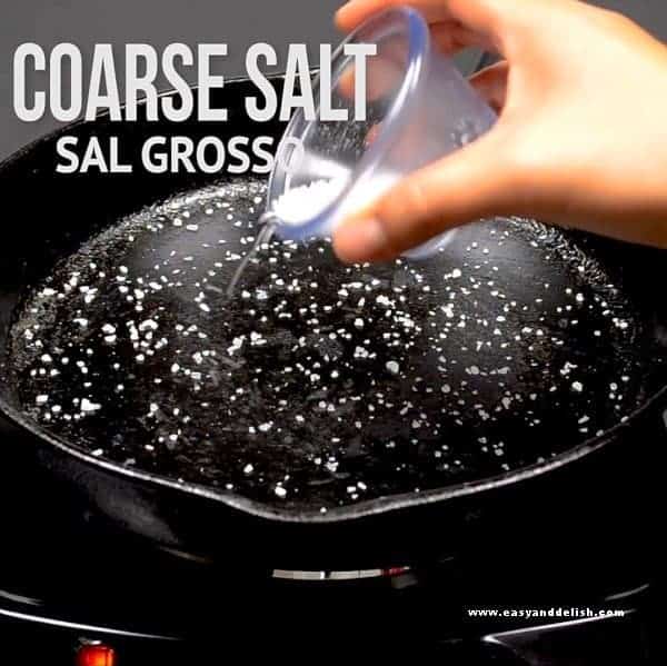 placing coarse salt in a pan to cook skirt steak