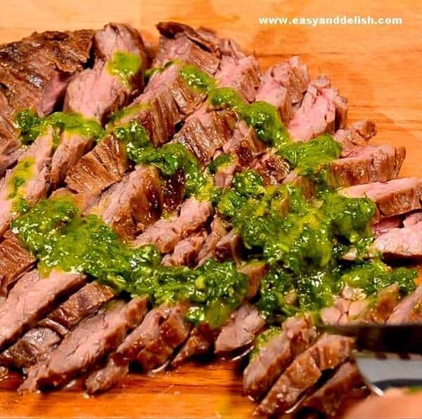 a close up of skirt steak topped with chimichurri sauce -- one of our quick and easy low carb dinner recipes