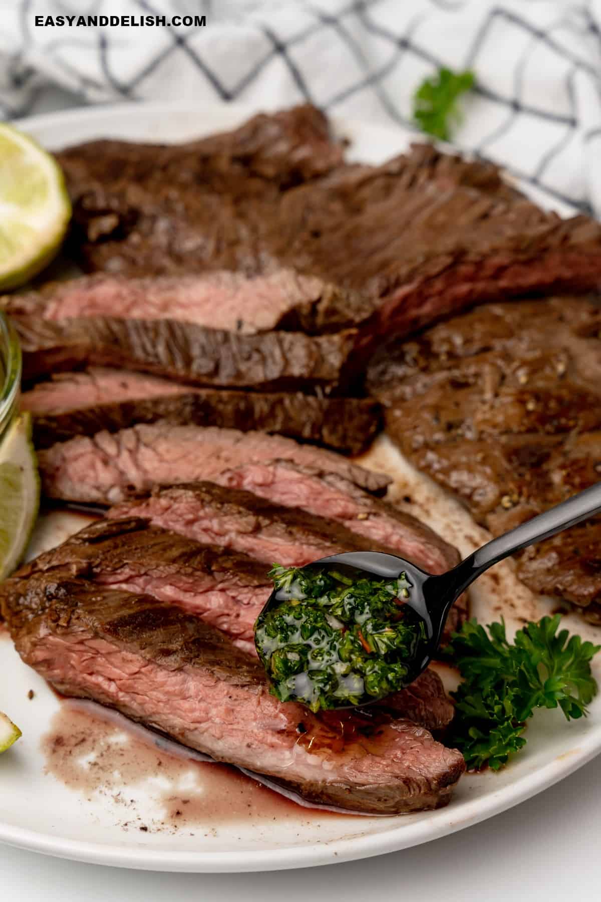 slied skirt steak with a spoon of chimichurri sauce on top