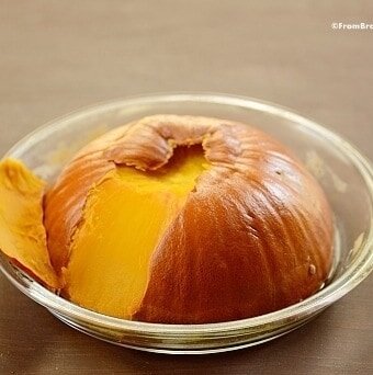 cooked pumpkin half with the shell being peeled away