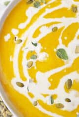 close up of creamy pumpkin soup with herbs