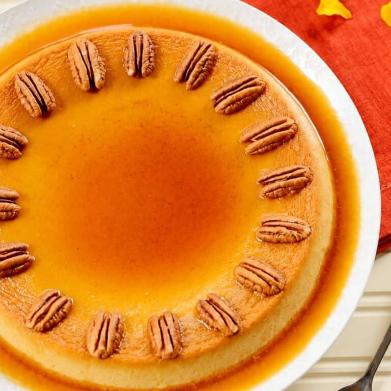 Pumpkin custard topped with roasted pecans and surrounded by caramel sauce.