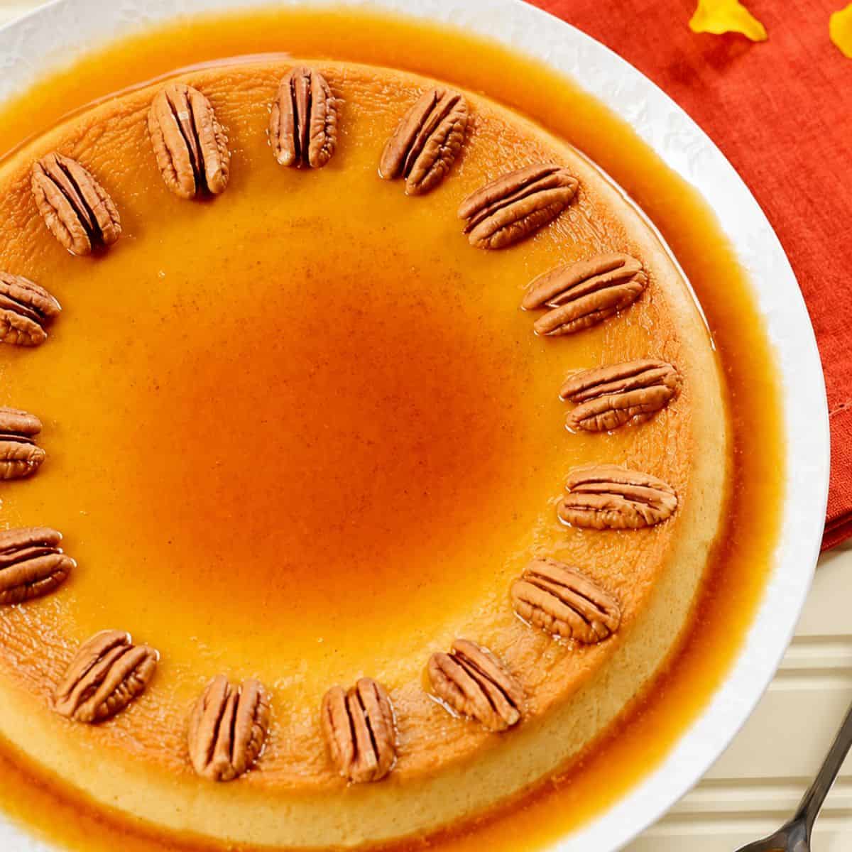 Pumpkin custard topped with roasted pecans and surrounded by caramel sauce.