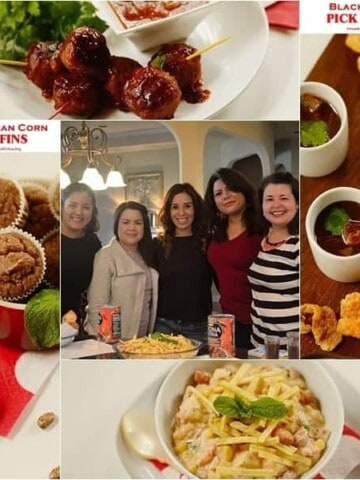 A bunch of different types of food on a table plus people standing in the center