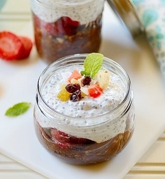 Breakfast in a jar sitting on top of a table with sliced strawberries
