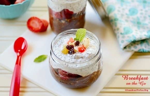 Breakfast in a jar sitting on top of a table with sliced strawberries