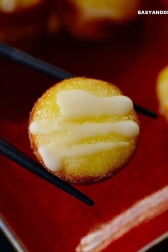 close up of sweet rice cake between chopsticks.