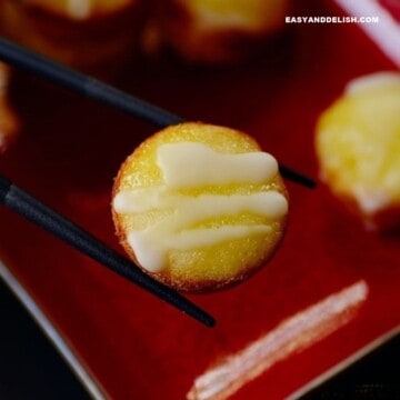 close up of sweet rice cake between chopsticks.