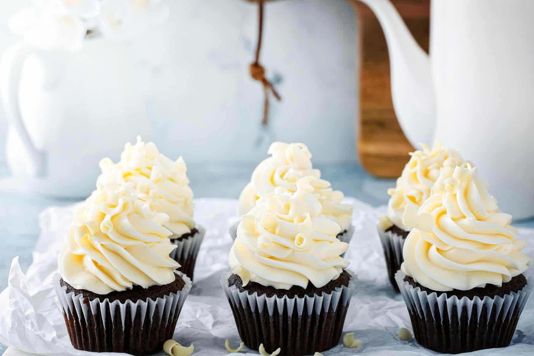 chocolate baked goods frosted with cream cheese frosting in a tray.