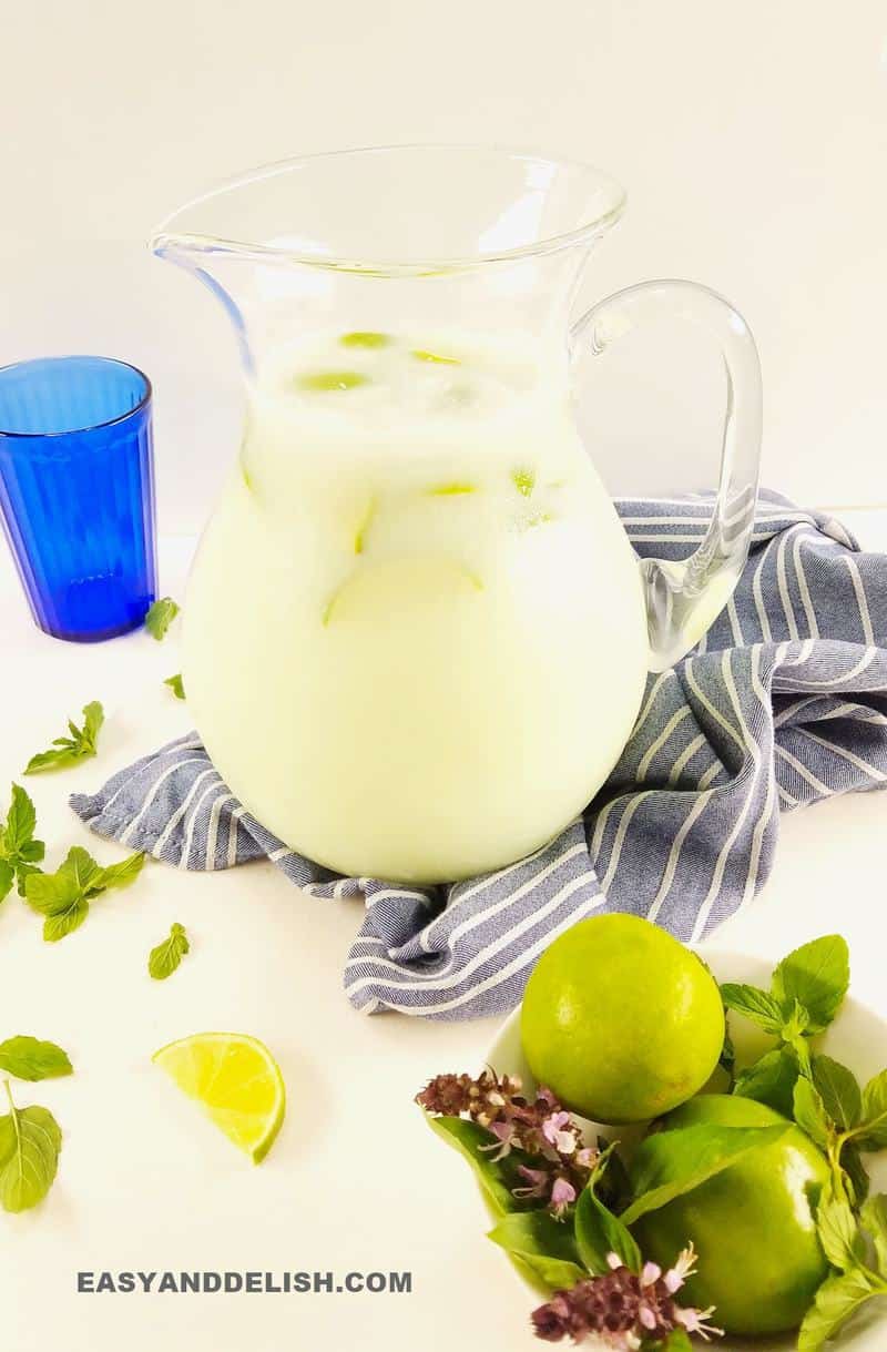 a picther with Brazilian limeade and limes around