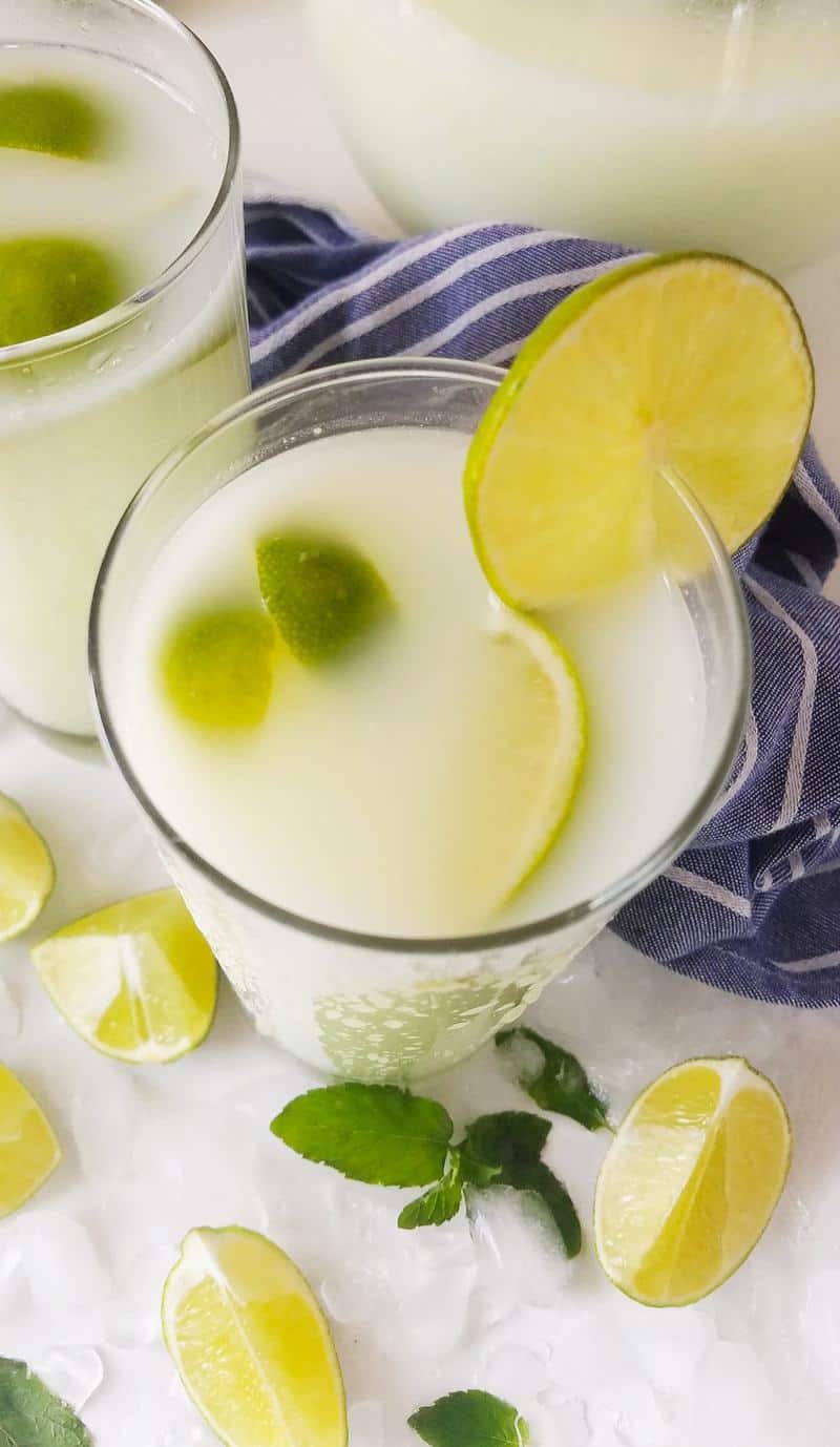 a glass with Brazilian lemonade and lime slices