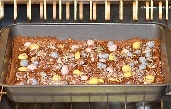 Easter mini egg cookie bars being baked in a pan