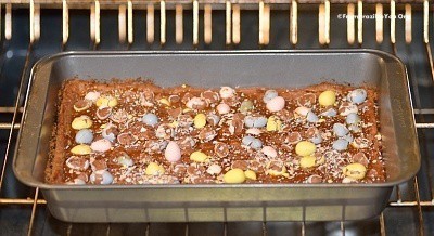Easter mini egg cookie bars being baked in a pan