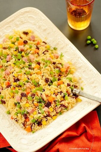 Greek rice or arroz a grega served on a white dish with a fork and red napkin