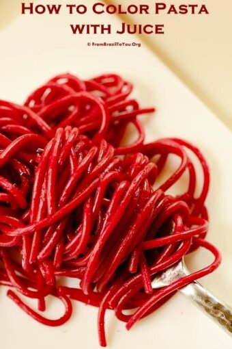 pasta colored red with beet juice being twirled on a fork
