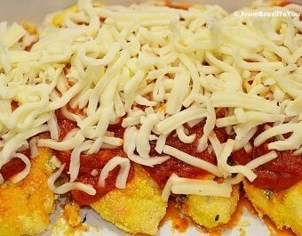 A close up of chicken with sauce and cheese