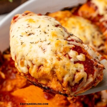 a breast of gluten-free chicken parmesan baked and then lifted witha spatula to be served