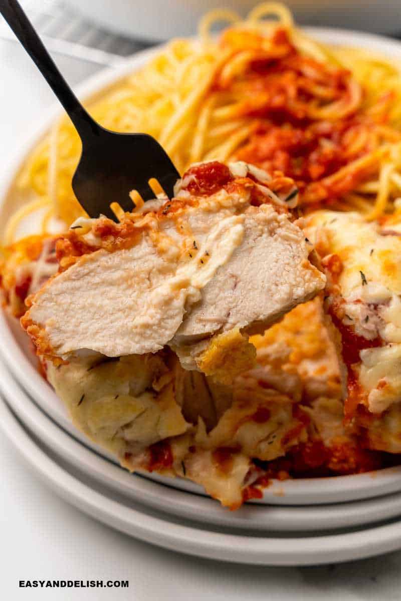 a piece of chicken in fork with pasta