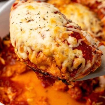 A close up of chicken breast topped with cheese