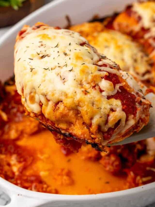 A close up of chicken breast topped with cheese