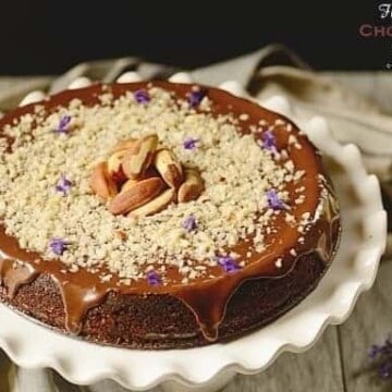 A chocolate cake decorated with Brazil nuts