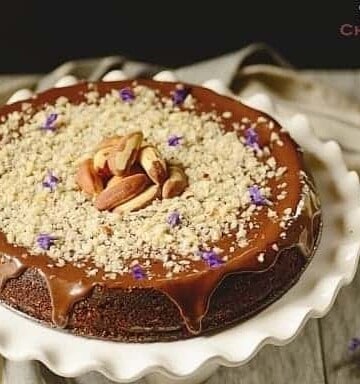 A chocolate cake decorated with Brazil nuts