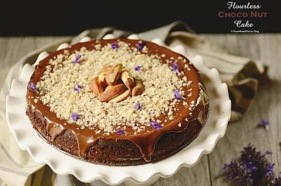 A chocolate cake decorated with Brazil nuts