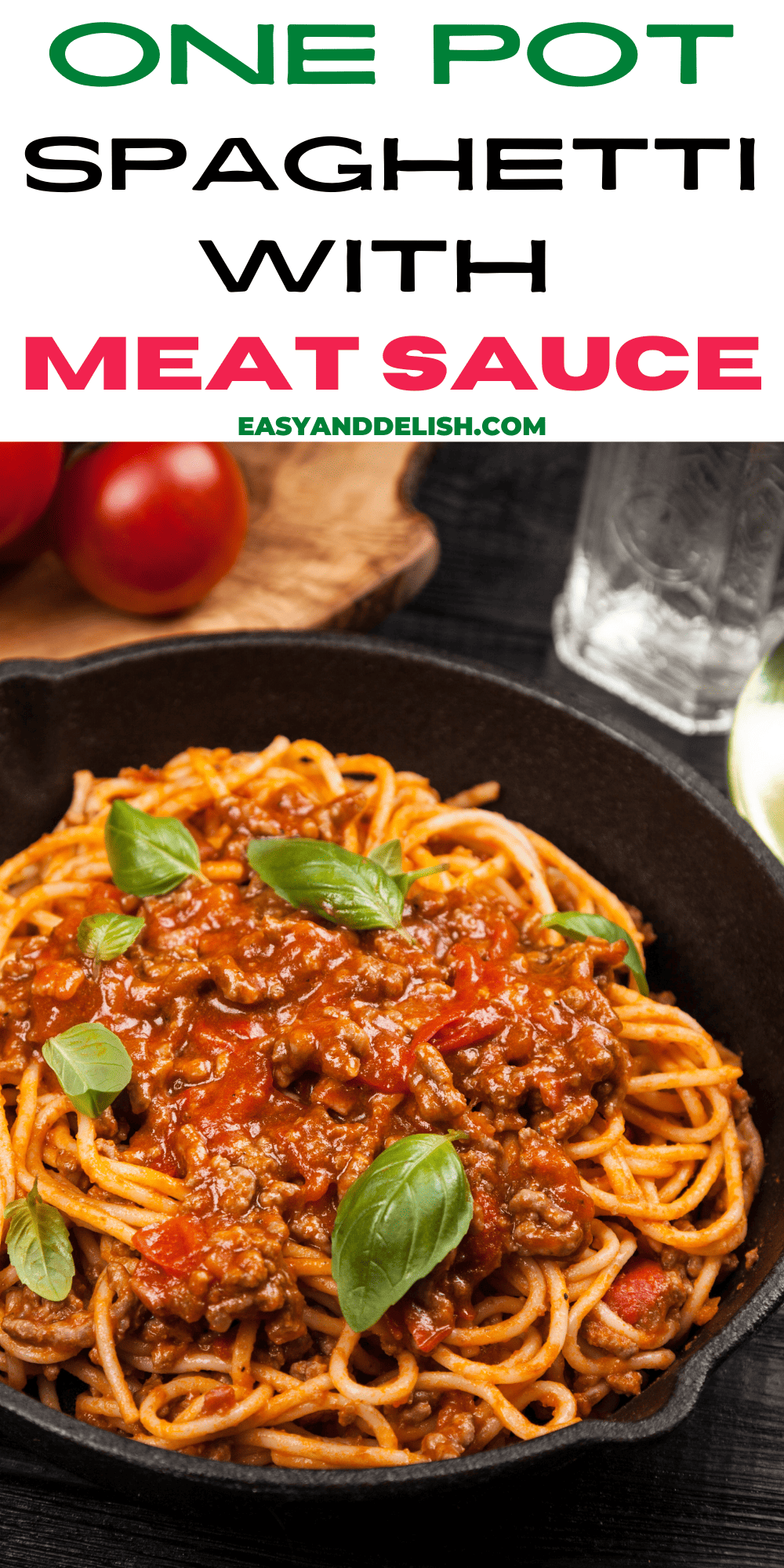 one pot spaghetti with meat sauce with some tomatoes in the background.