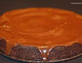 chocolate glaze being poured over chocolate nut cake