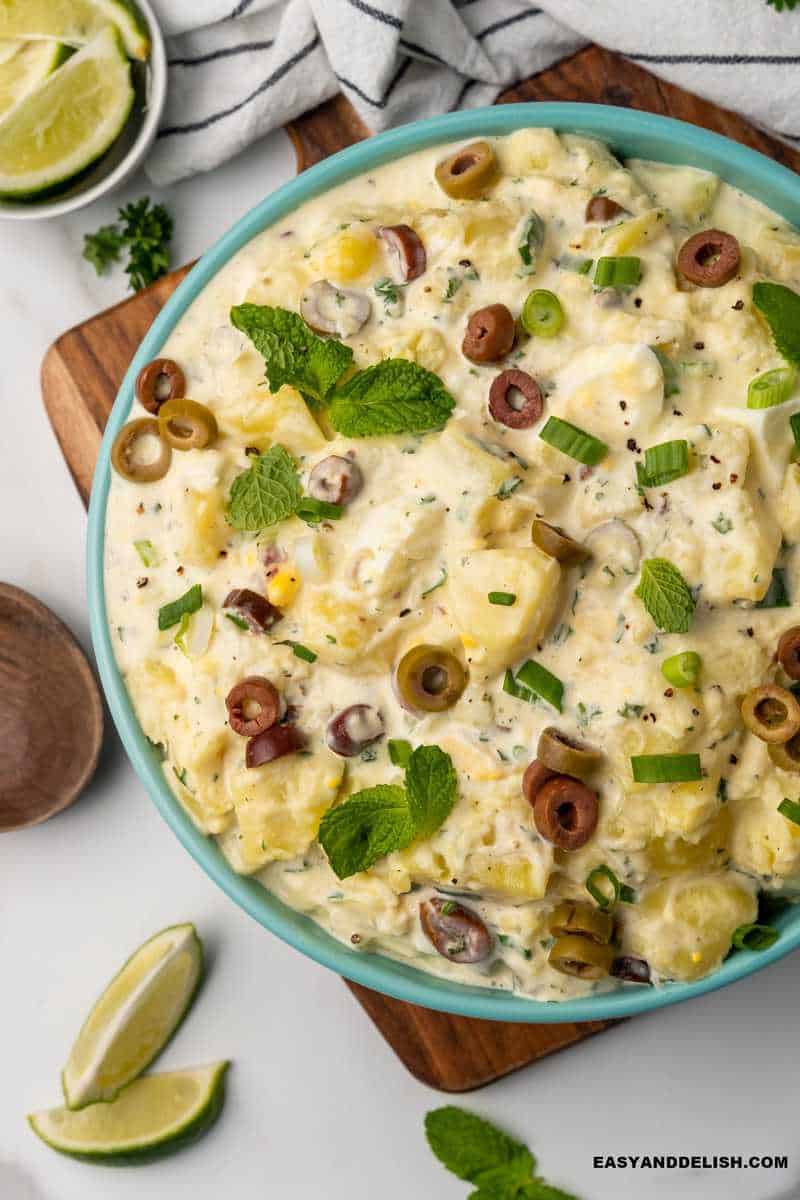 potato salad with mayonnaise ina bowl with garnishes on the side