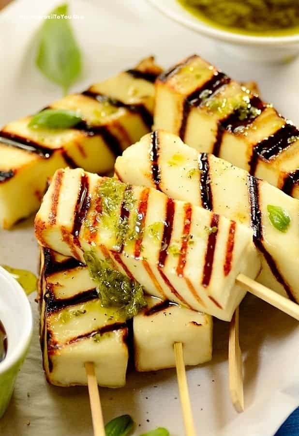 CLOSE UP IMAGE OF GRILLED CHEESE STICKS TOPPED WITH CHIMICHURRI