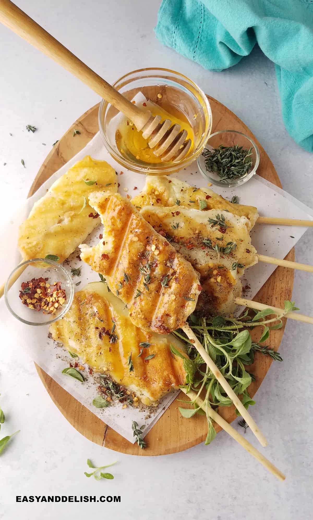 a tray with sticks of grilling cheeses a dn some garnishes on the side, made with halloumi.