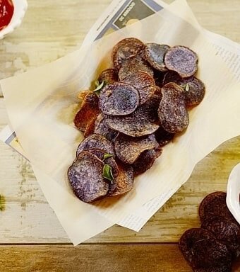 purple potato chips in a paper-lined basket