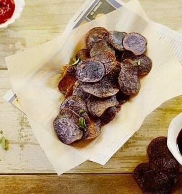 purple potato chips in a paper-lined basket