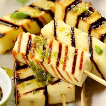 close up of grilled cheese skewers with some chimichurri on top.