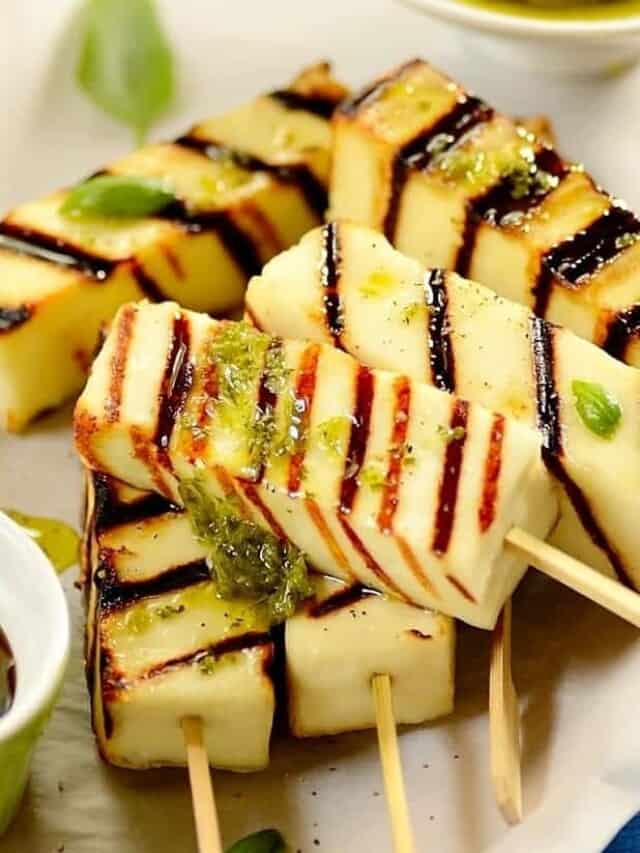 close up of grilled cheese skewers with some chimichurri on top, made with paneer. 